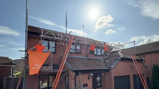 Scaffolding up against a brick semi-detached house before a roof install